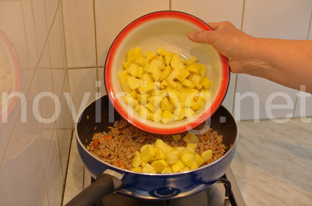 Мусака с кайма и броколи - изсипване на картофите
